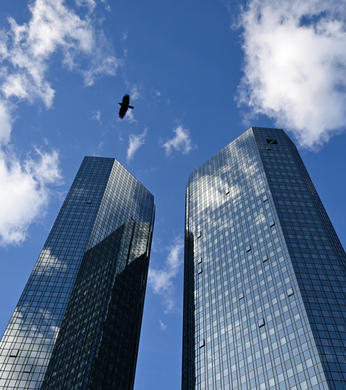 Wolken spiegeln sich in der Glasfassade der Zwillingstürme der Zentrale der Deutschen Bank. 