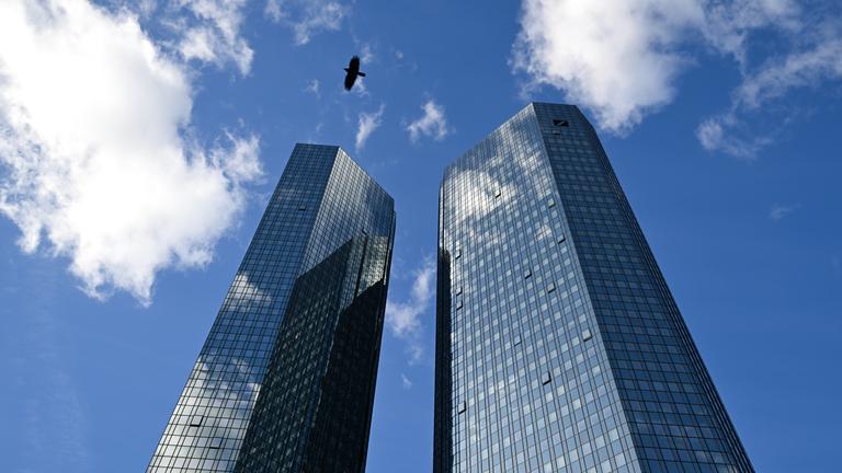 Wolken spiegeln sich in der Glasfassade der Zwillingstürme der Zentrale der Deutschen Bank. 