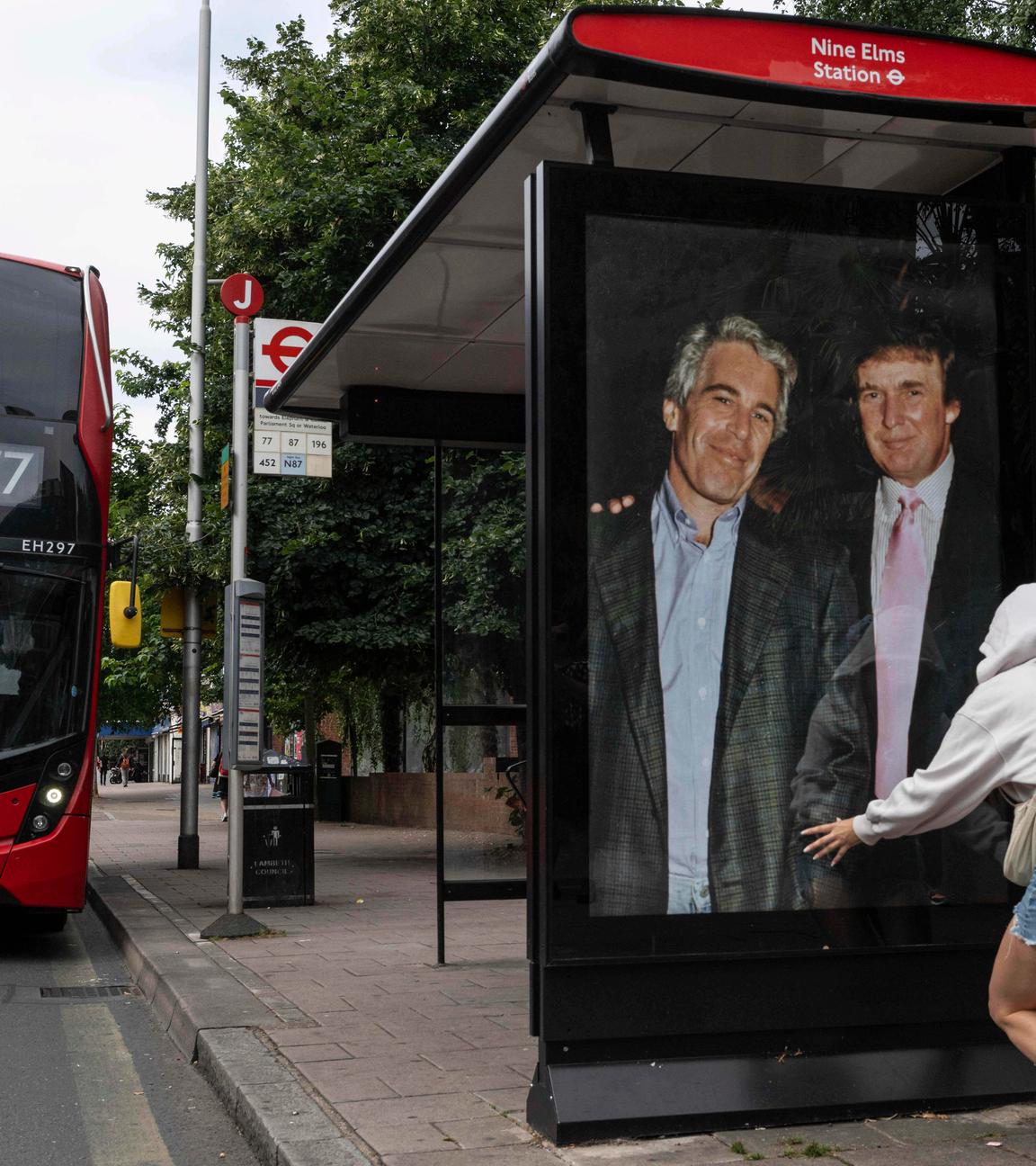 Großbritannien, London: Aktivisten hängen ein Plakat, das US-Präsident Donald Trump und Jeffrey Epstein zeigt, an einer Bushaltestelle in der Nähe der US-Botschaft auf.