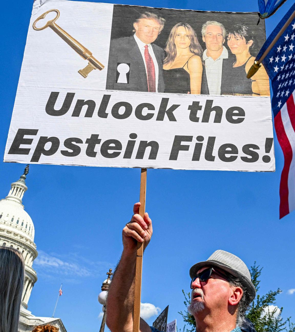 Ein Mann hält ein Schild mit der Aufschrift "Unlock the Epstein Files" hoch.