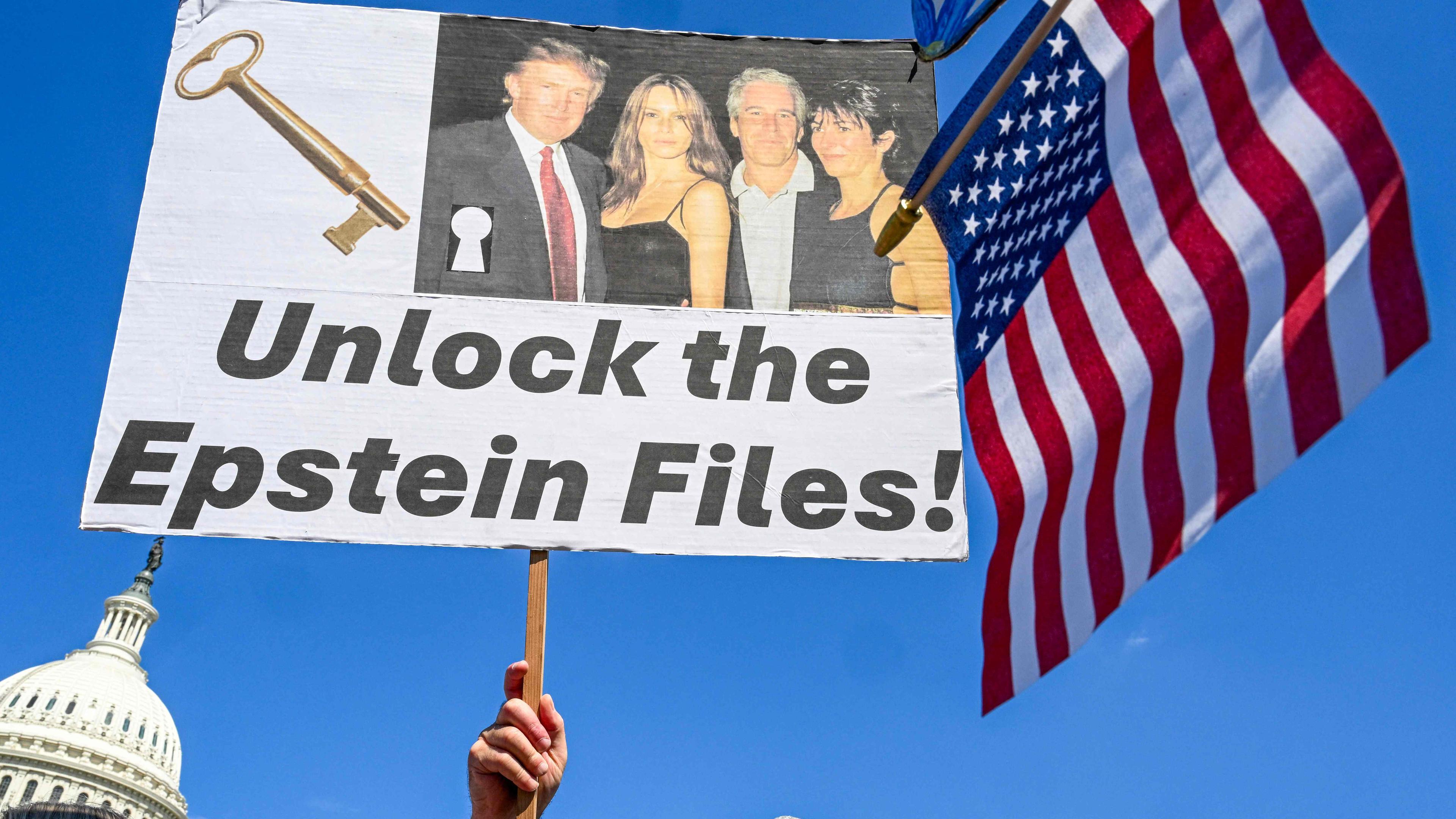 Ein Mann hält ein Schild mit der Aufschrift "Unlock the Epstein Files" hoch.