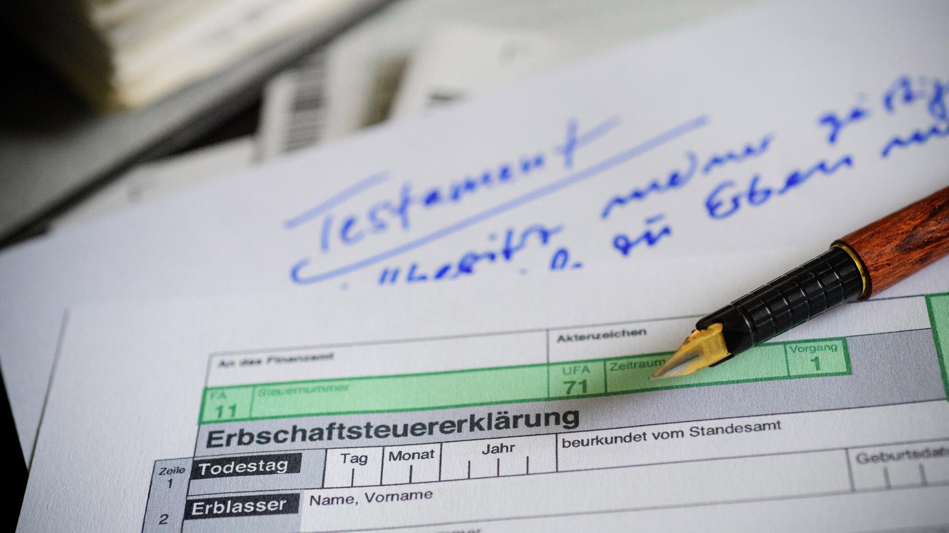 Ein Formular zur Erbschaftssteuer liegt über einem Papier mit der Aufschrift "Testament".