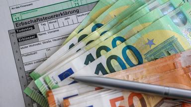 Sachsen, Leipzig: Auf einem Bogen zur Erbschaftsteuererklärung liegen Geldscheine von 100 und 50 Euro.