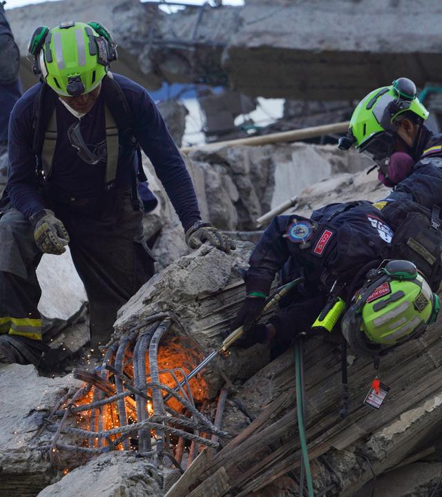 Rettungskräfte suchen in den Trümmern nach Überlebenden.