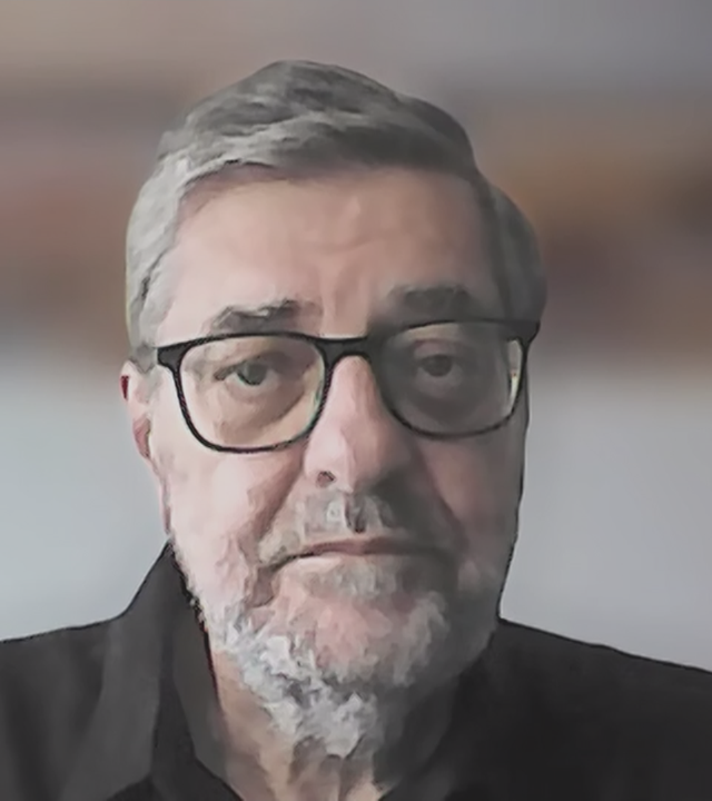 Latein-Amerika Experte Günther Maihold in einem schwarzen Hemd und einer schwarzen Brille. Man sieht ihn ab den Schultern aufwärts. Der Hintergrund ist unscharf gestellt.