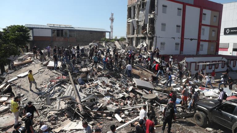 Kolumbien, Cali: Anwohner und Rettungskräfte durchsuchen die Trümmer eines eingestürzten Gebäudes, nachdem ein Erdbeben die kolumbianische Stadt Cali erschüttert hat.
