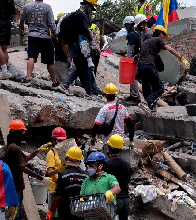 Menschen helfen bei Rettungsarbeiten an eingestürzten Gebäuden in Cali, Kolumbien, nach einem schweren Erdbeben.
