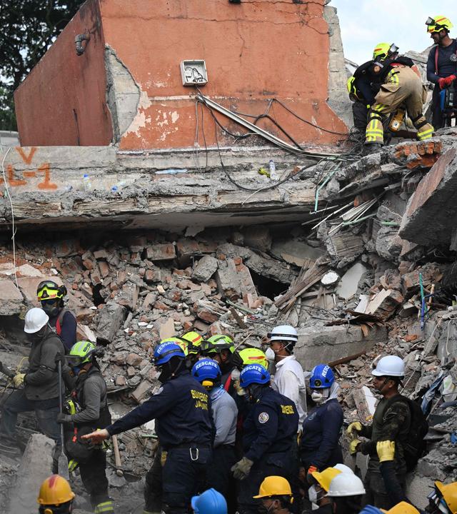 Feuerwehrleute suchen am Ort eingestürzter Gebäude nach Überlebenden, nachdem sich in Cali (Kolumbien) ein Erdbeben ereignet hat.
