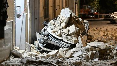 Steine und Trümmerteile liegen nach einem Erdbeben bei Neapel auf einem Auto, das dadurch zerstört ist.