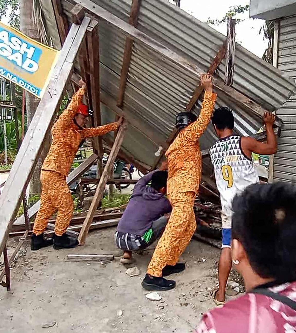 Mitglieder des Amts für Brandschutz (Bureau of Fire Protection) und Anwohner reparieren eine beschädigte Zimmerdecke in der Stadt Baganga, Provinz Davao Oriental auf der südlichen Insel Mindanao, nachdem am 10. Oktober 2025 ein starkes Erdbeben der Stärke 7,4 den Süden der Philippinen erschüttert hat.