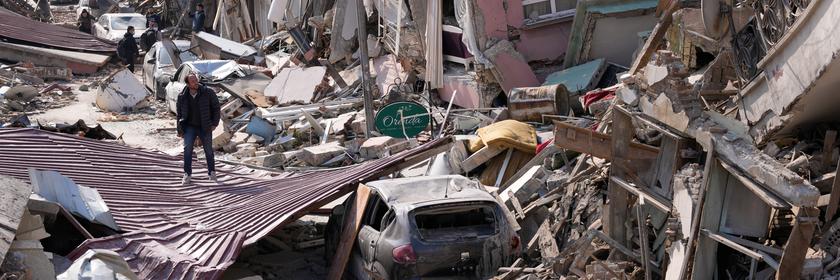 Ein Mann geht über die Trümmer eingestürzter Gebäude. Die Zahl der Toten nach den Erdbeben im türkisch-syrischen Grenzgebiet ist auf mehr als 25 000 gestiegen.