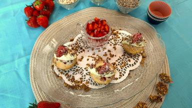 Erdbeer-Muffins mit Mascarpone und Granola von Mario Kotaska angerichtet auf einem Teller. Toppings stehen daneben.