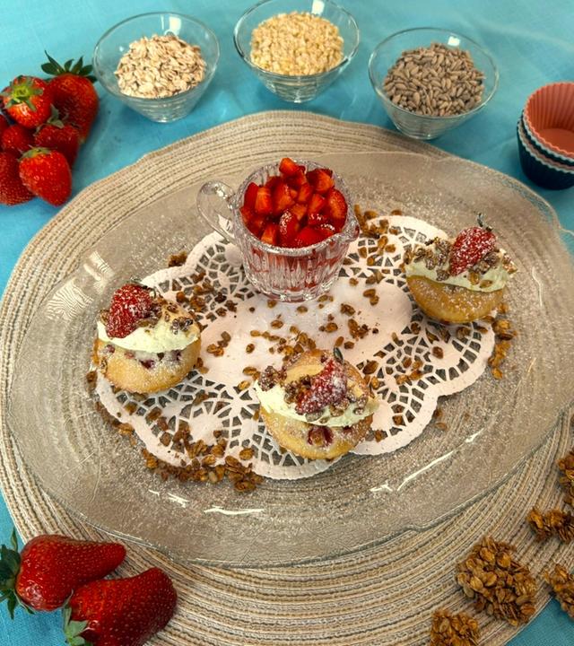 Erdbeer-Muffins mit Mascarpone und Granola von Mario Kotaska angerichtet auf einem Teller. Toppings stehen daneben.