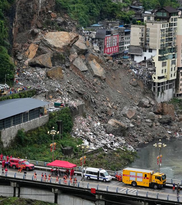 Rettungskräfte stehen am Samstag, dem 18. Juli 2026, auf der Brücke bereit, während sie sich auf einen Such- und Rettungseinsatz an der Stelle eines Erdrutsches im Kreis Pengshui (Stadtunmittelbare Stadt Chongqing, Südwestchina) vorbereiten.