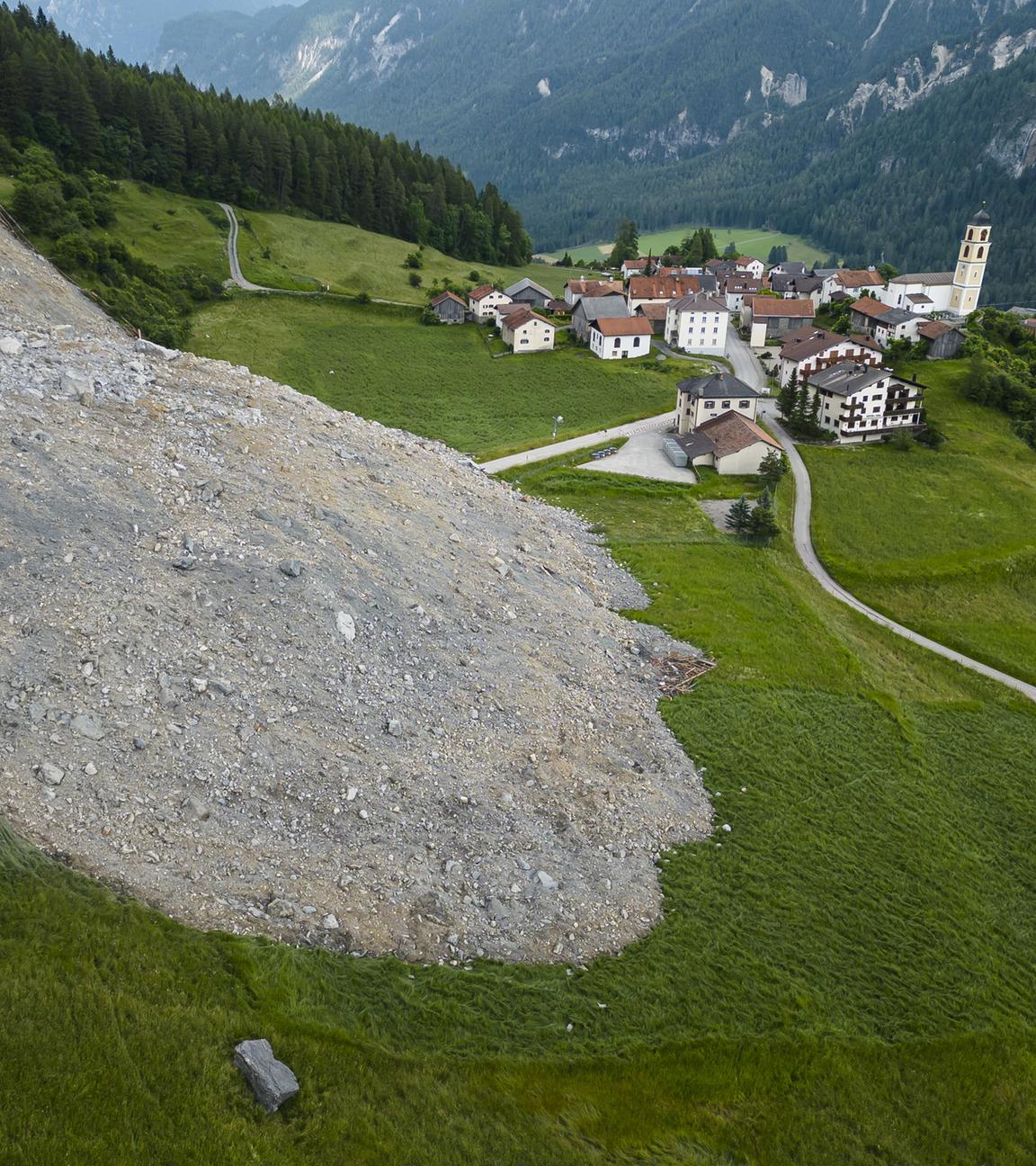 Eine Luftaufnahme zeigt eine mit dem Felssturz „Brienzer Rutsch“ bedeckte Straße im Dorf Brienz-Brinzauls, Kanton Graubünden, Schweiz.