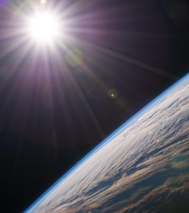 Die Sonne scheint über dem Horizont der Erde, während die Internationale Raumstation über der kanadischen Provinz Quebec kreist.