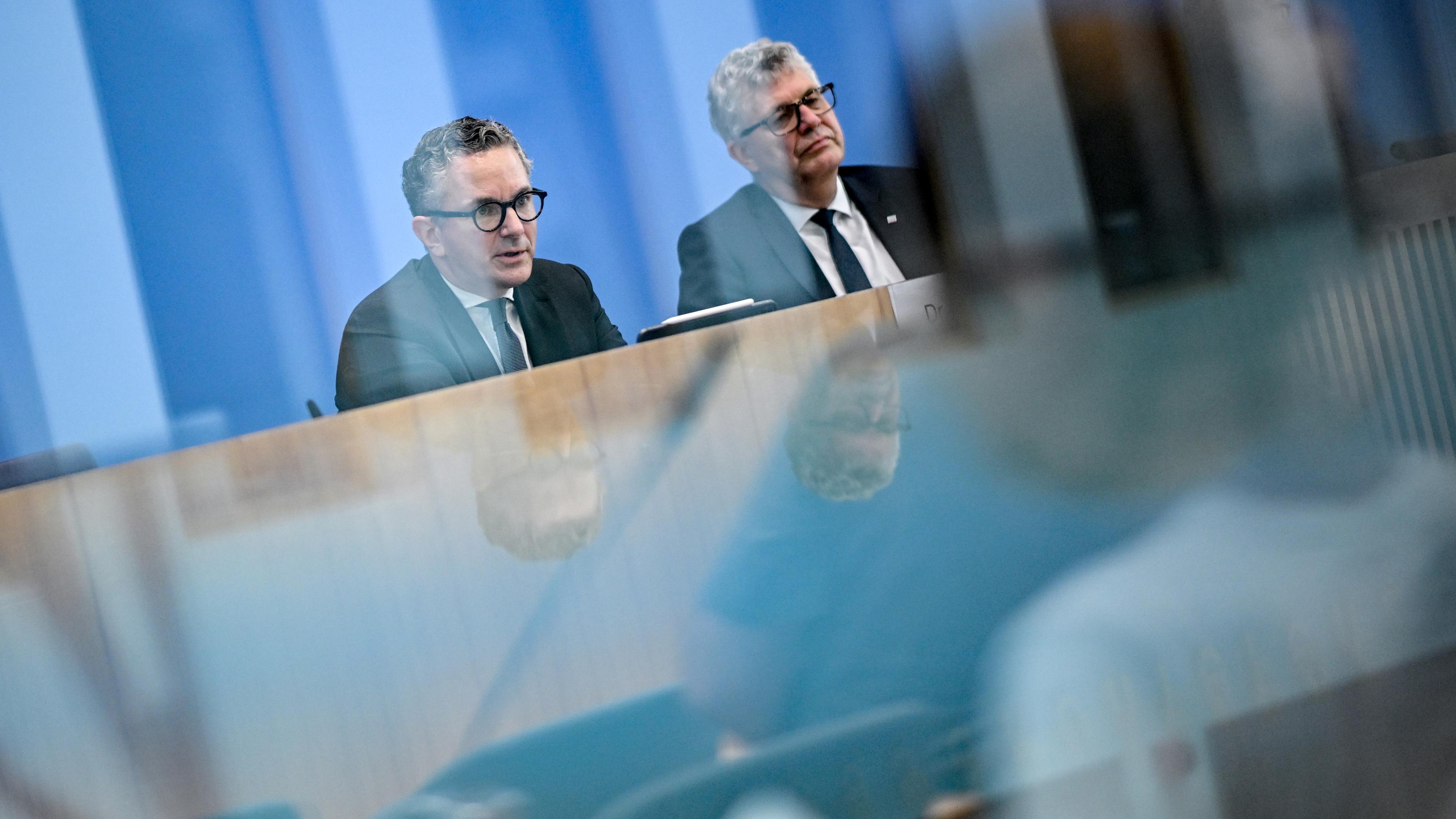 05.09.2025, Berlin: Thorsten Rudolph (l), haushaltspolitischer Sprecher der SPD-Bundestagsfraktion und Christian Haase, haushaltspolitischer Sprecher der CDU/CSU-Bundestagsfraktion, sprechen bei einer Pressekonferenz zu den Ergebnissen der Bereinigungssitzung des Haushaltsausschusses zum Bundeshaushalt 2025 und spiegeln sich in einer Glasscheibe.