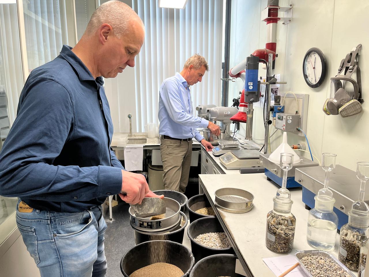 Erik Schlangen (links) und Henk Jonkers stehen in einem Labor der TU Delft.