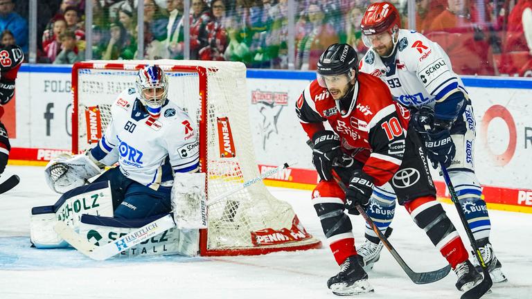 Der Eishockeyspieler der Kölner Haie, Tanner Kero, führt den Puck in der Nähe des Tores der Schwenninger Wild Wings, bedrängt von Kyle Platzer.