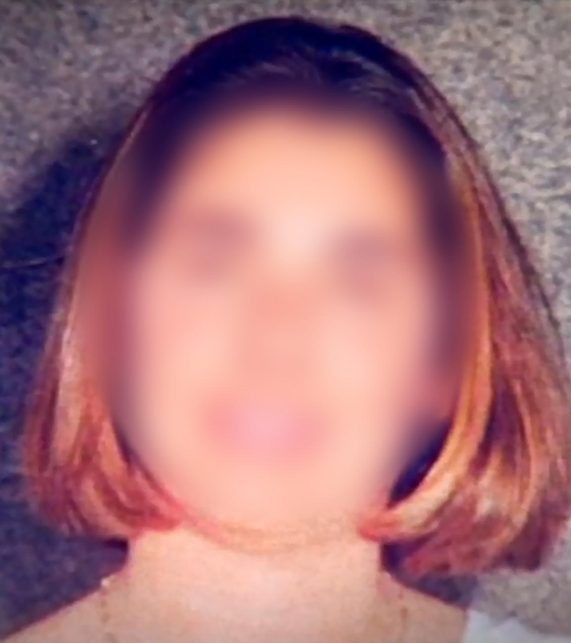 Bei einer Porträtaufnahme eienr jungen Frau mit schulterlangem rotbraunen Haar ist das Gesicht unkenntlich gemacht und nur verschwommen zu erkennen.