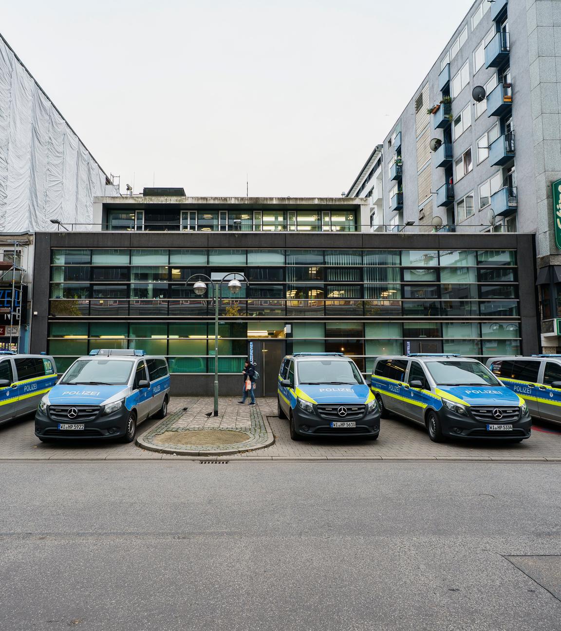  Einsatzfahrzeuge der Polizei stehen vor dem ersten Polizeirevier. 