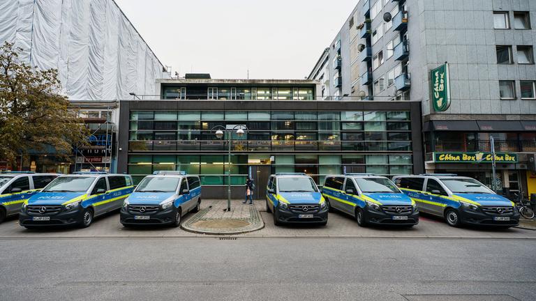  Einsatzfahrzeuge der Polizei stehen vor dem ersten Polizeirevier. 