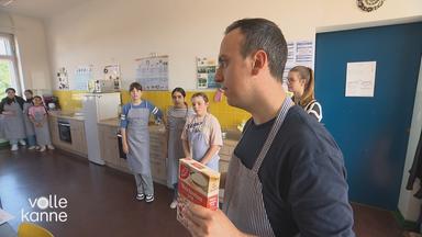 Lehrer steht mit Weizenmehl vor Kindern