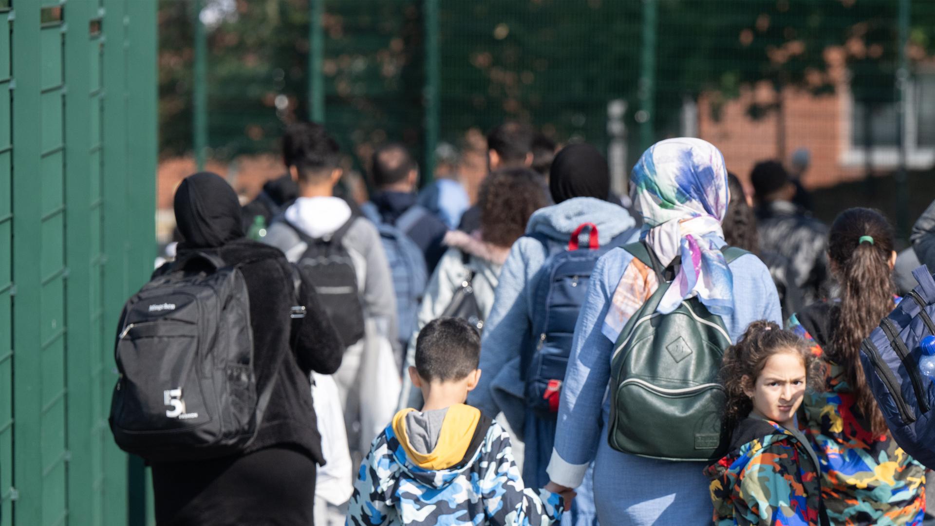 Gezeigt werden Geflüchtete bei ihrer Ankunft bei einer Erstaufnahmeeinrichtung in Gießen.