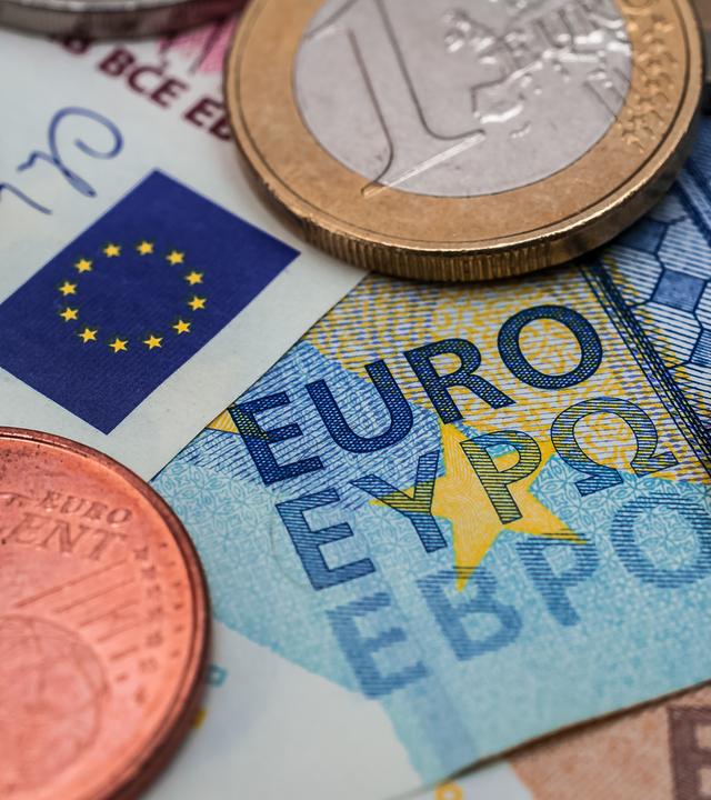 Gelscheine und Euro-Münzen liegen verteilt.