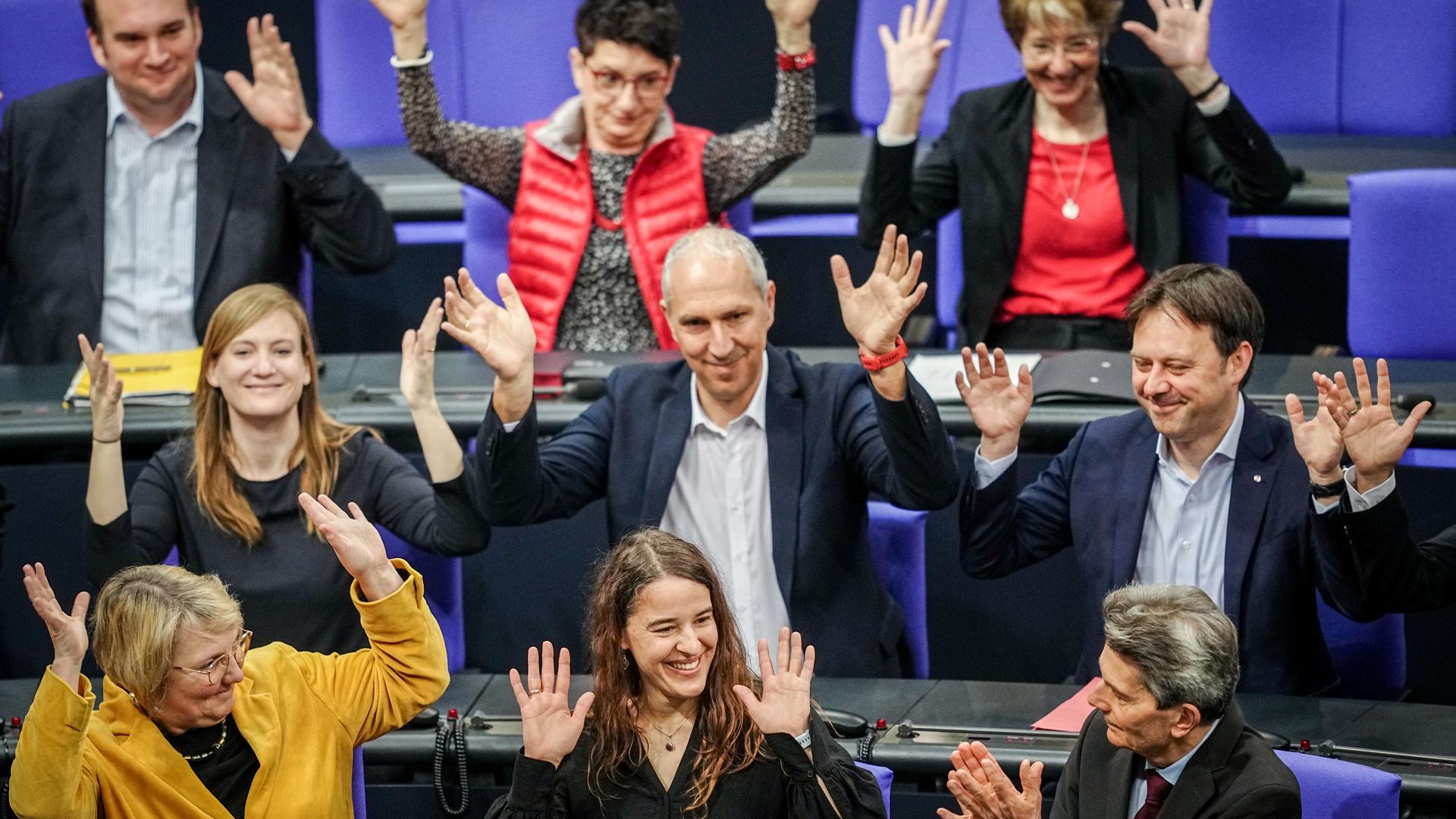 Bundestagsabgeordnete applaudieren in Gebärdensprache für Heike Heubach, die in der Mitte am unteren Bildrand sitzt.