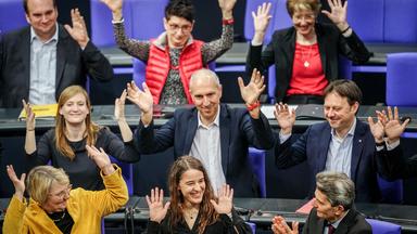 Bundestagsabgeordnete applaudieren in Gebärdensprache für Heike Heubach, die in der Mitte am unteren Bildrand sitzt.