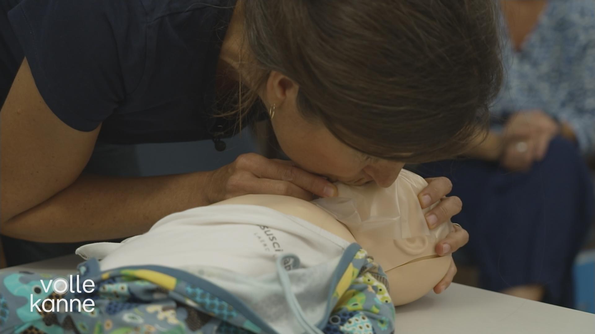 Frau gibt Baby-Dummy Mund-zu-Mund-Beatmung