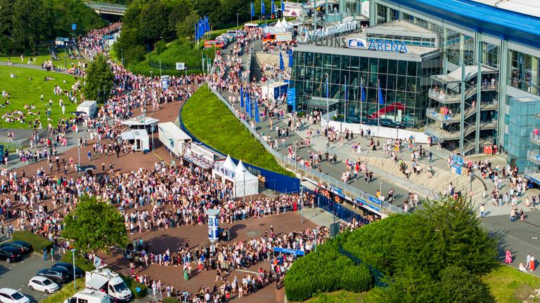 Lange Schlangen haben sich an den Eingängen zur Veltins-Arena gebildet.