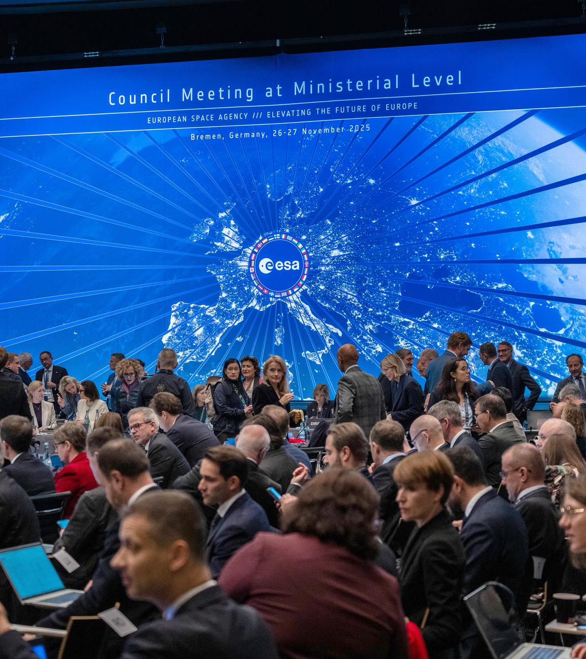 Im Sitzungssaal der Esa-Ministerratstagung nehmen Teilnehmende Platz. 