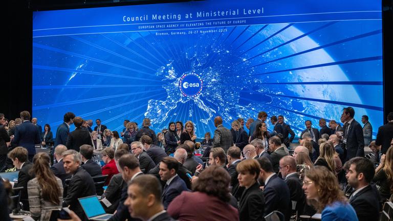 Im Sitzungssaal der Esa-Ministerratstagung nehmen Teilnehmende Platz. 