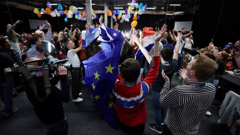Menschen tanzen mit EU-Flagge im Medienzentrum während des zweiten Halbfinales der 68. Ausgabe des Eurovision Song Contest (ESC) in der Malmo Arena in Malmö, Schweden