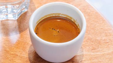 Frisch gebrühter Espresso in einer kleinen Tasse auf einem Tisch serviert