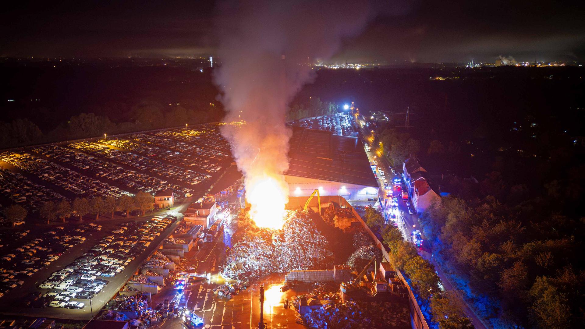 Flammen und Rauch steigen in den nächtlichen Himmel über dem Essener Stadtteil Altenessen: Ein Schrottberg brennt.