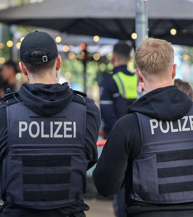 Nordrhein-Westfalen, Essen: Polizisten stehen vor einem Absperrband.