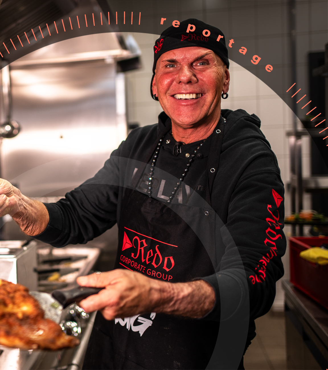 Koch René Dost posiert in seiner Küche mit einem großen panierten Schnitzel.