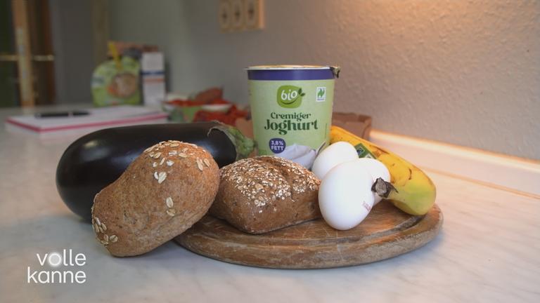 verschiedene gesunde Lebensmittel (Vollkornbrot, Bio-Joghurt, Eier, Banane) im Bild