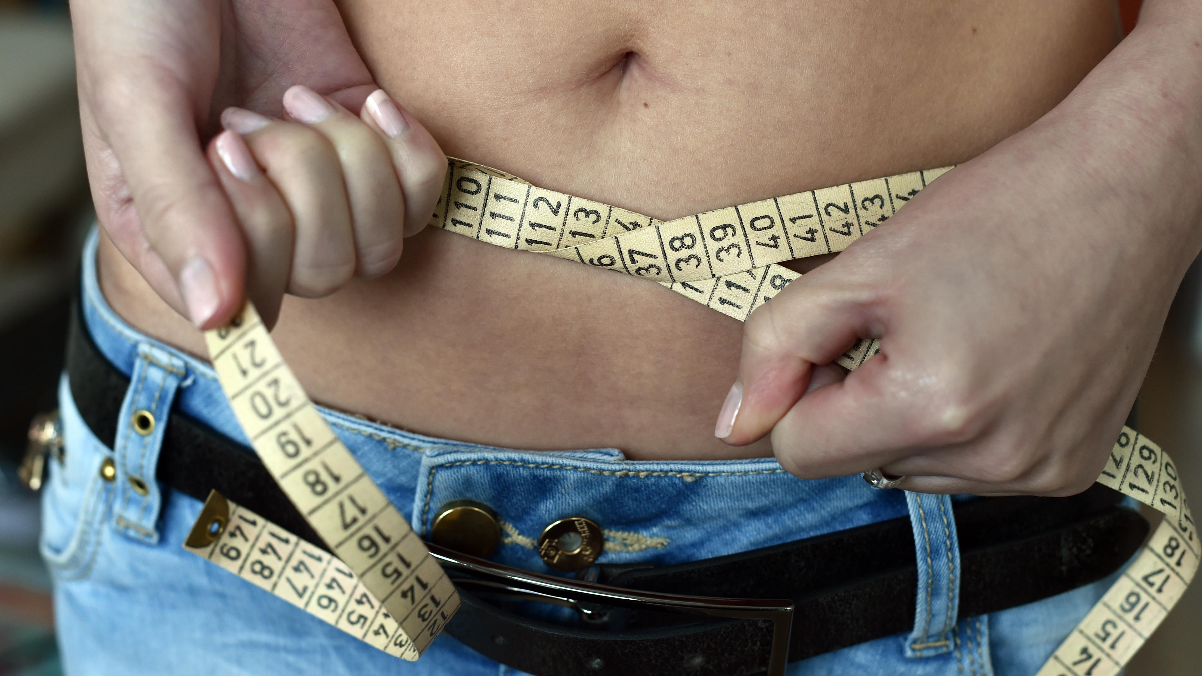 Berlin: Eine junge Frau legt ein Maßband um ihren Bauch.