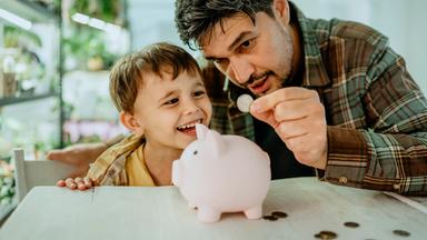 Vater lehrt Sohn, zu Hause Geld zu sparen.