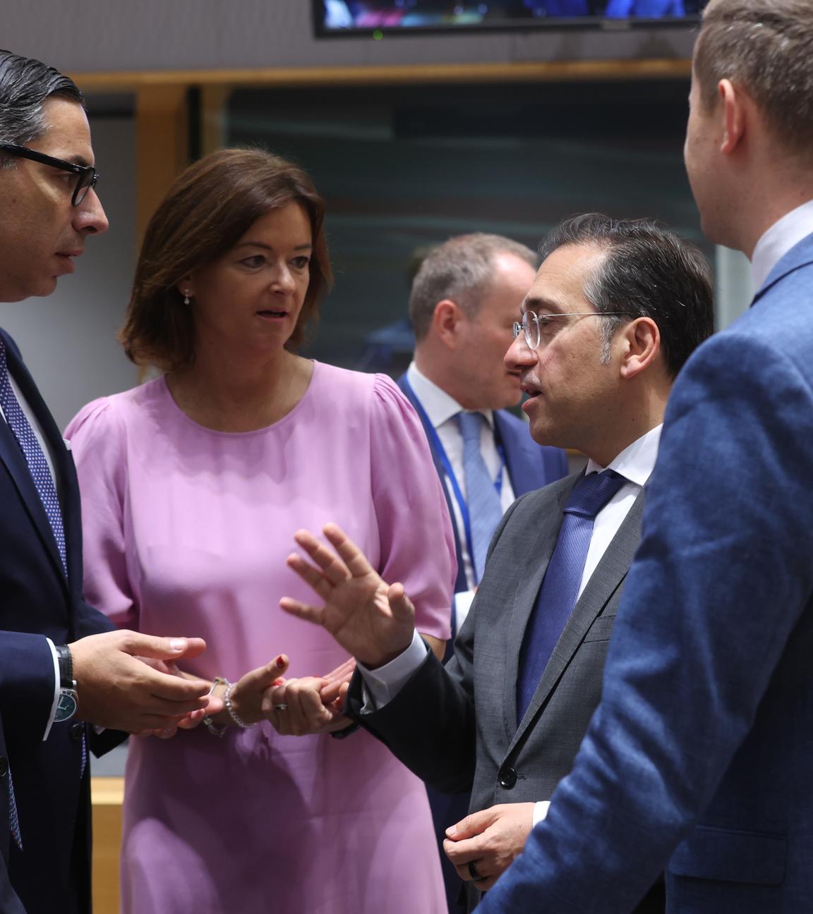 Mehrere europäische Außenminister*innen stehen im Kreis und reden miteinander. Sie gestikulieren.