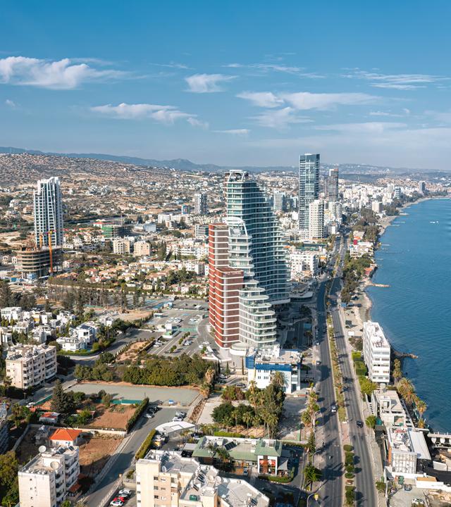 Stadtbild von Limassol, Zypern, mit modernen Wolkenkratzern, die sich entlang der Mittelmeerküste erheben.