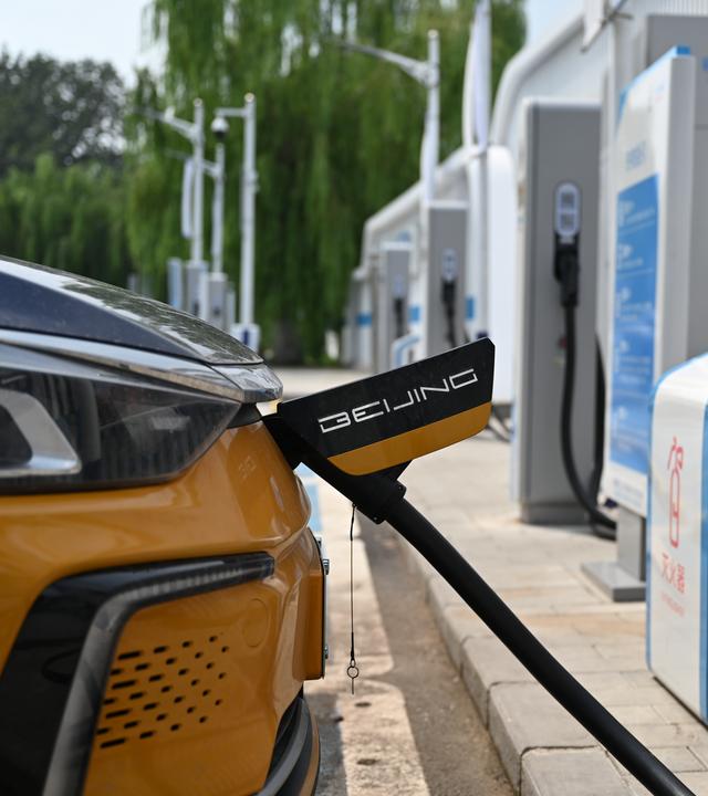 15.08.2024, China, Peking: Ein Pekinger Taxi lädt an einer Ladesäule für E-Autos.
