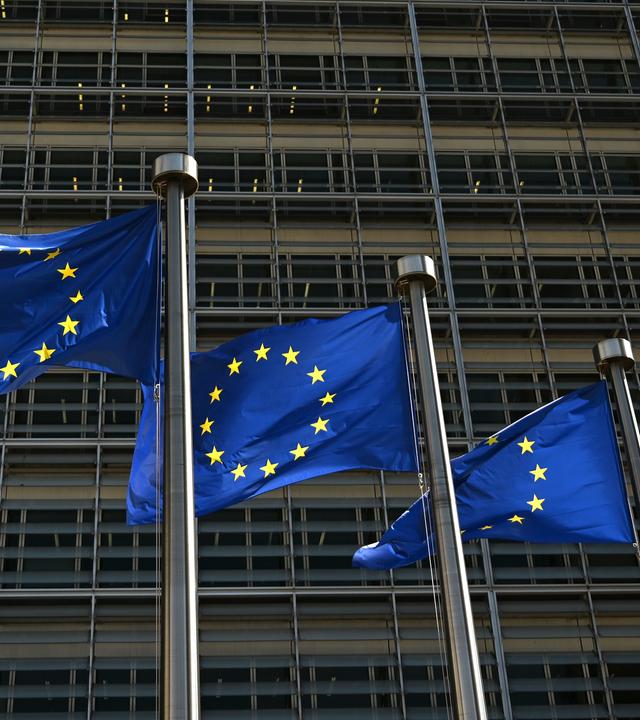  Fahnen mit dem Logo der Europäischen Union wehen vor dem Gebäude der Europäischen Kommission im Wind. 