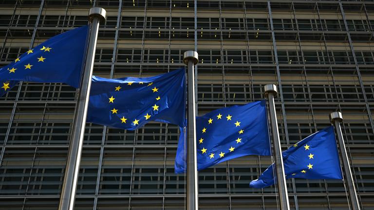  Fahnen mit dem Logo der Europäischen Union wehen vor dem Gebäude der Europäischen Kommission im Wind. 