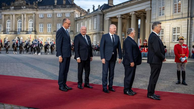 Bundeskanzler Friedrich Merz (CDU, l) kommt zum Abendessen am Schloss Amalienborg im Rahmen des informellen Treffens der EU-Staats- und Regierungschefs an und wartet mit anderen Gästen auf seine Begrüßung.