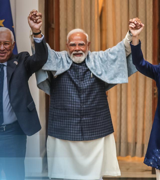 Die EU und Indien haben ein Handelsabkommen abgeschlossen - das Teaserbild zeigt Ursula von der Leyen und zwei indische Politiker, die die Hände in die Höhe reißen und sich freuen